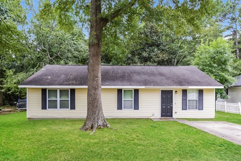 a small white house with a tree in the front